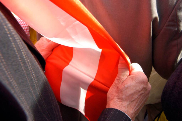 homem segurando bandeira austríaca vermelho-branco-vermelho em suas mãos
 - Foto, Imagem