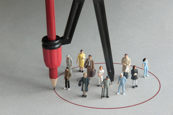 Circle drawn around a group of miniature people with a compass; immunity, vaccination, antibody protection - 写真・画像