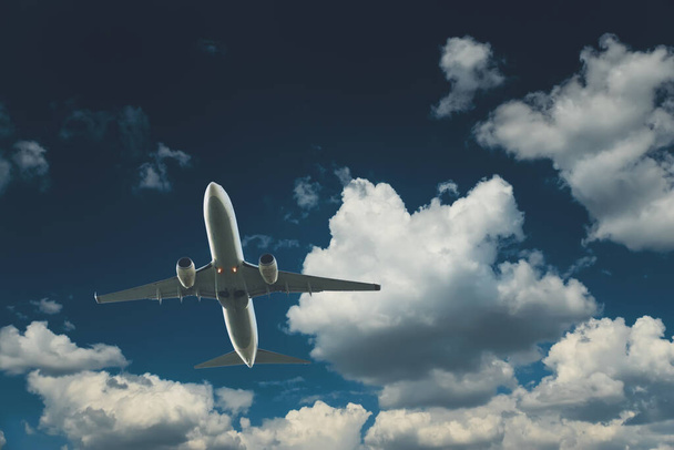 Commercial airplane flying through clouds in dramatic sky. Travel concept - Valokuva, kuva