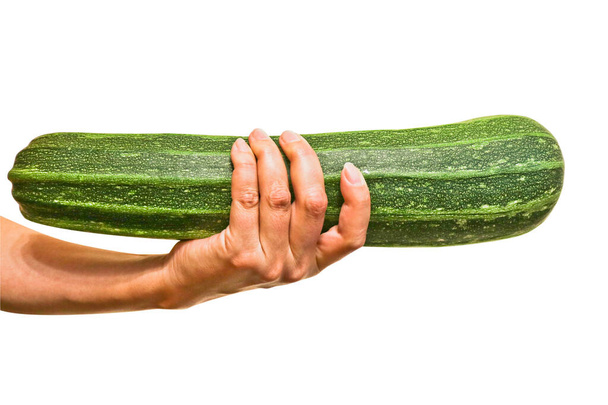Zucchine verdi fresche in una mano femminile. Cibo vegano sano. Isolato. Primo piano
. - Foto, immagini