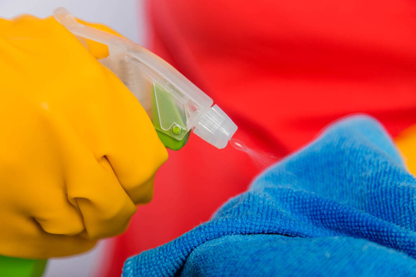 Close-up of spray bottle and rag in the hands of a cleaning lady. Concept art of cleaning the premises and the prevention of viral diseases. - Foto, imagen
