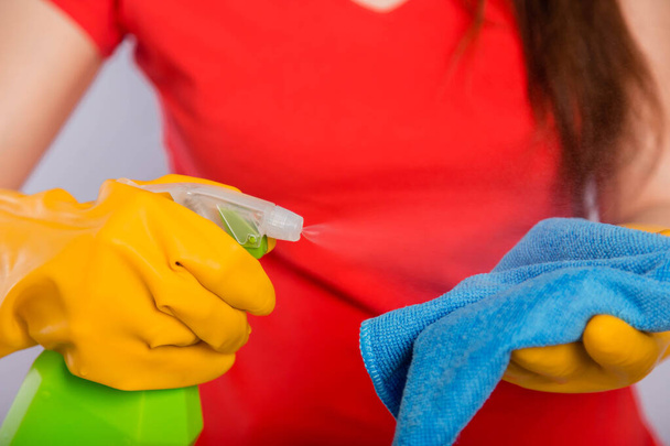 Close-up of spray bottle and rag in the hands of a cleaning lady. Concept art of cleaning the premises and the prevention of viral diseases. - Φωτογραφία, εικόνα