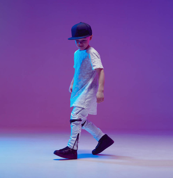 Cool young boy child dancing hip hop in the Studio against the background of neon lights. Break dance poster. - Фото, зображення