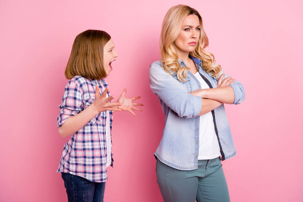 You dont understand me. Outraged kid daughter yell mother avoid disagreement cross hands feel sad offense wear casual checkered plaid denim jeans shirt isolated pastel color background - 写真・画像
