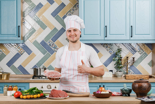 Joven hermoso chef masculino presenta la comida en la cocina - Foto, imagen