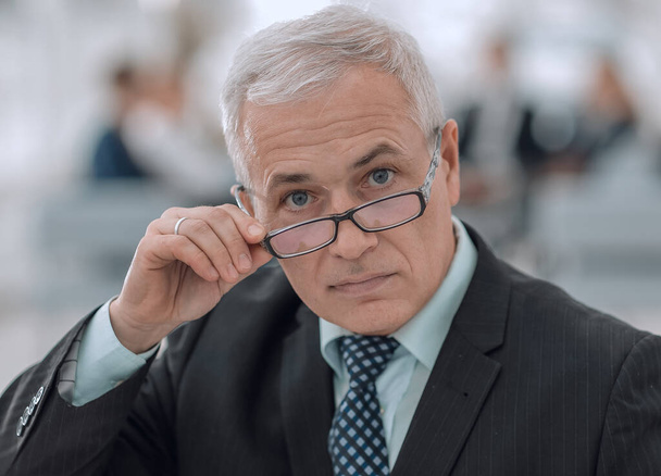 closeup of a senior businessman adjusting his glasses - Photo, image