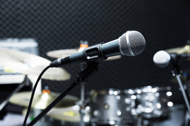 Professional condenser studio microphone, Musical Concept. recording, selective focus  microphone in radio studio, selective focus microphone and blur musical equipment guitar ,bass, drum piano background. - Photo, Image