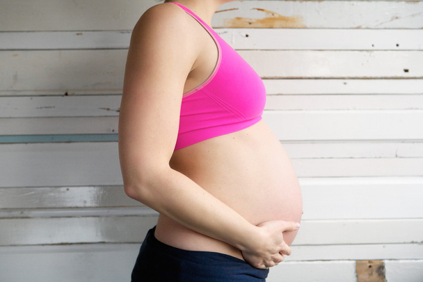 kant weergave portret van een zwangere vrouw maag houden - Foto, afbeelding