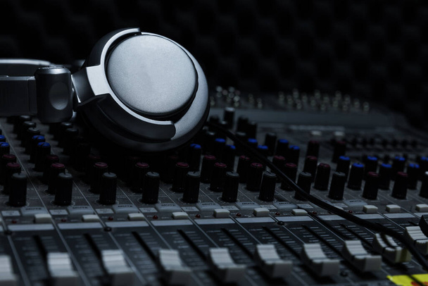 Close-up de balcão de controle de estúdio de gravação boutique, fones de ouvido dj para disco profissional, equipamentos para estúdio de gravação de som, mixer e fones de ouvido DJ
 - Foto, Imagem