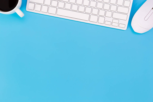 плоский настільний стіл Офісний стіл сучасного робочого місця з ноутбуком на синьому столі, видом зверху на фоні ноутбука та копіювання простору на чорному фоні, синій настільний офіс з ноутбуком, смартфоном та іншими робочими приладдям за допомогою миші
. - Фото, зображення