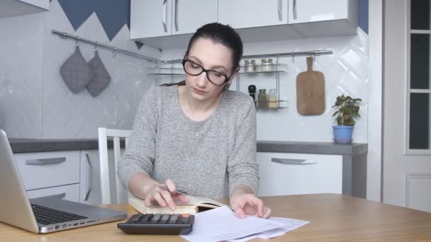 Young woman feeling stressed and upset by high taxes, bills or mortgage rate. Calculating household payments. Accountant works from home calculating bank debt invoice. - Séquence, vidéo
