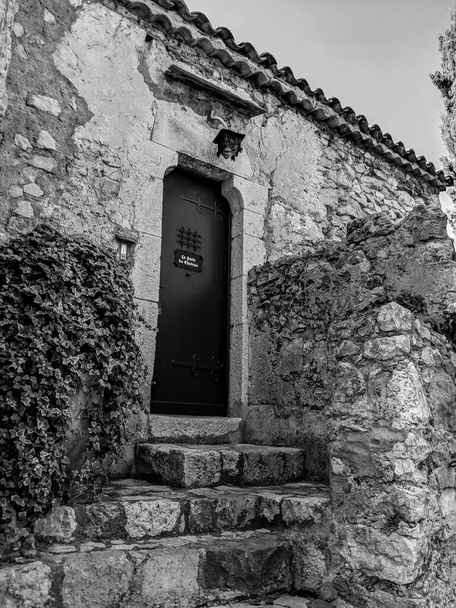 エズ村の古い建物の石造りの入り口の黒と白の写真、フランスのリビエラ - 写真・画像