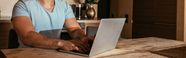 przycięty widok mężczyzn mieszane rasy freelancer pracy z laptopem na kuchni podczas samoizolacji, nagłówek strony internetowej - Zdjęcie, obraz