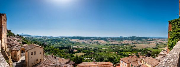 Panorama der Weinberge des Val d 'Orcia von der mittelalterlichen Stadt Pienza in der Toskana, Italien. 2004 wurde das Val d 'Orcia in die UNESCO-Liste des Weltkulturerbes aufgenommen. - Foto, Bild