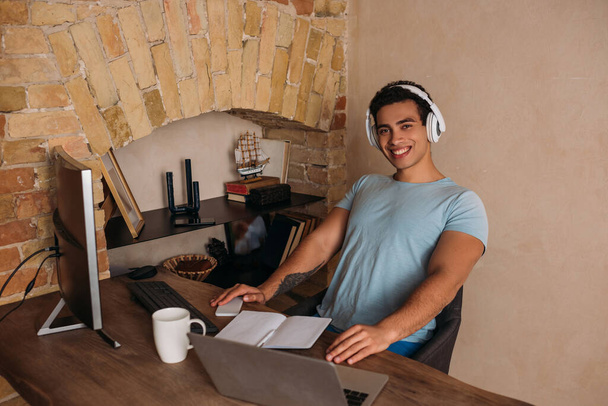 freelancer de raça mista sorrindo trabalhando em home office durante quarentena
 - Foto, Imagem