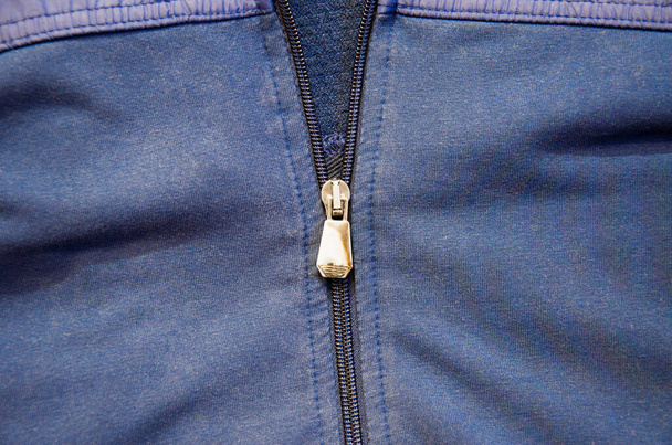 Metalowy zamek na męskiej niebieskiej kurtce. Niebieski strój sportowy - Zdjęcie, obraz