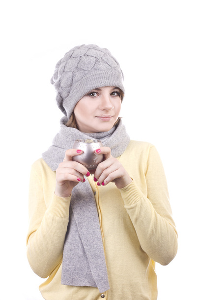 Lovely girl in a gray hat holding a Christmas candlestick on white background - Zdjęcie, obraz