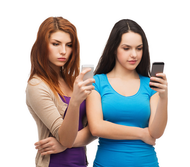 Two serious teenagers with smartphones - Photo, Image