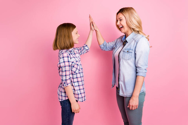 Profile side photo of excited satisfied candid mother girl win family competition best team hold highfive hand gesture wear denim jeans checkered plaid shirt isolated pastel color background - Foto, immagini