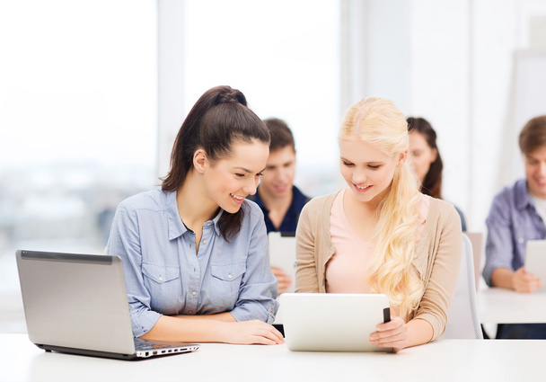 Dois estudantes sorridentes com laptop e tablet pc
 - Foto, Imagem