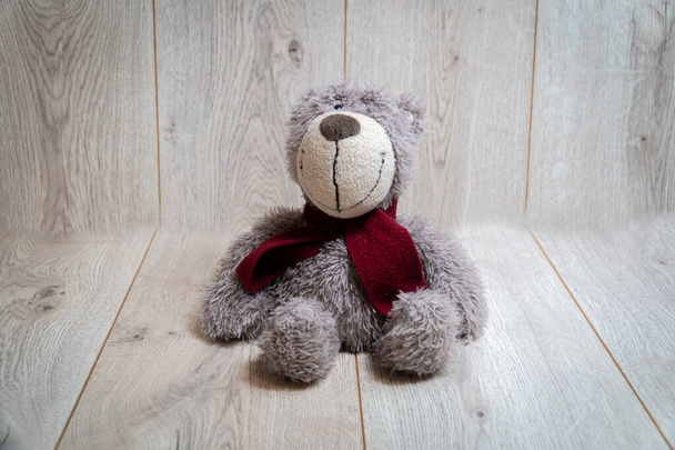 Мягкий медвежонок на деревянном фоне
 - Фото, изображение