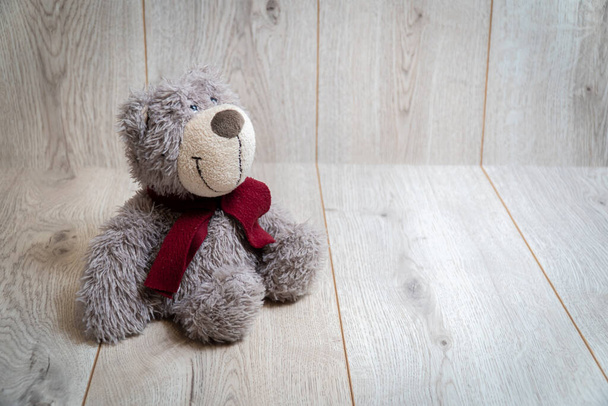 Мягкий медвежонок на деревянном фоне
 - Фото, изображение