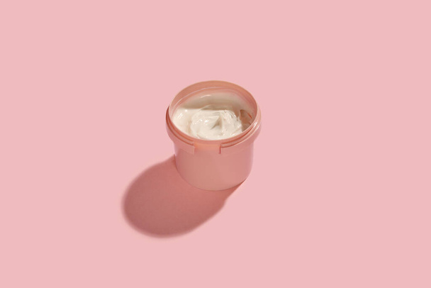 вид сбоку крема в банке на розовом фоне
 - Фото, изображение