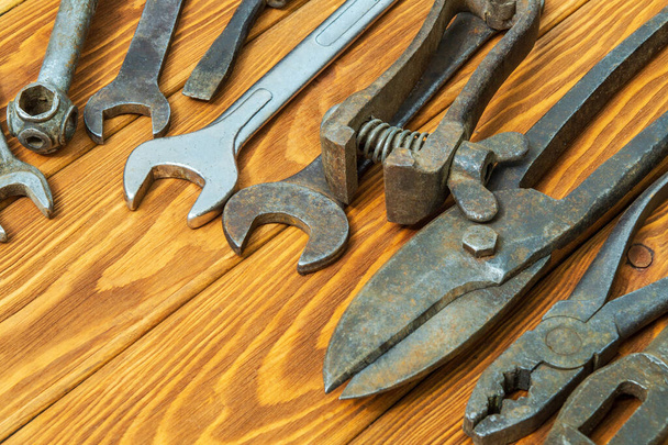 Vieux outils rouillés empilés après le travail sur fond de bois vintage
 - Photo, image
