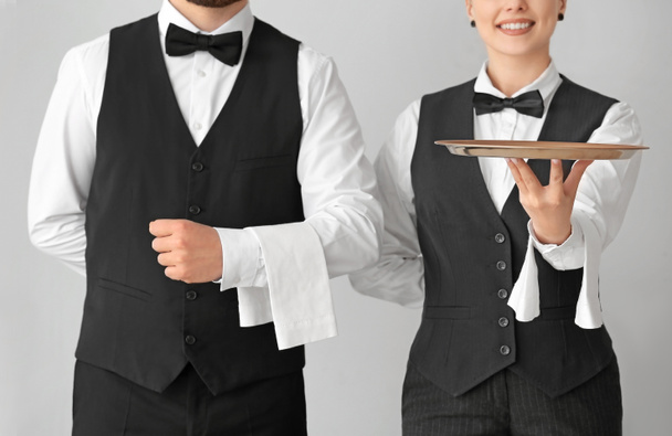 Mężczyzna i kobieta kelnerki na szarym tle - Zdjęcie, obraz