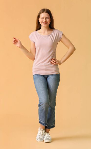 Junge Frau in stylischem T-Shirt auf farbigem Hintergrund - Foto, Bild
