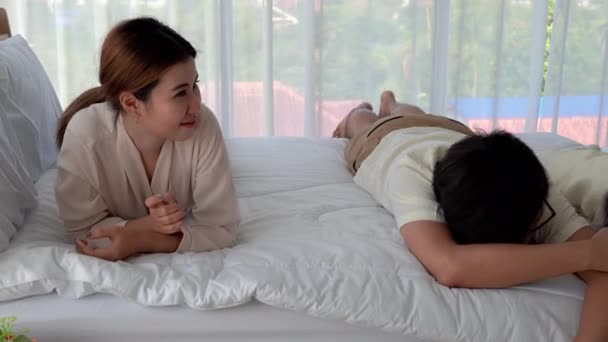 A szülők ugratják a lányaikat egy ágyban, egy boldog és vigasztaló házban.. - Felvétel, videó