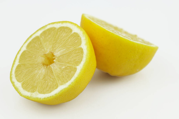 Frische Zitronenhälften isoliert auf weißem Hintergrund. Gelbe frische, in Scheiben geschnittene Zitrone auf weißem Hintergrund - Foto, Bild