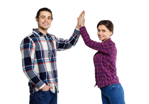 Photo of happy young people man and woman in basic clothing give fife isolated over white background. - Zdjęcie, obraz