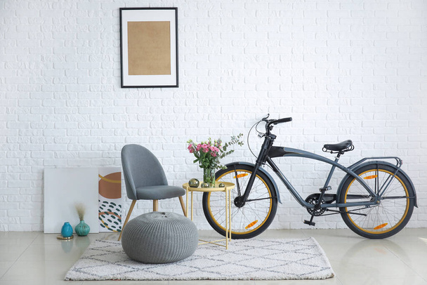 Intérieur de la chambre moderne avec chaise confortable, table et vélo
 - Photo, image