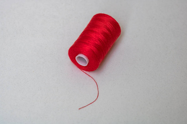 Red spool of sewing thread isolated, close up. - Φωτογραφία, εικόνα