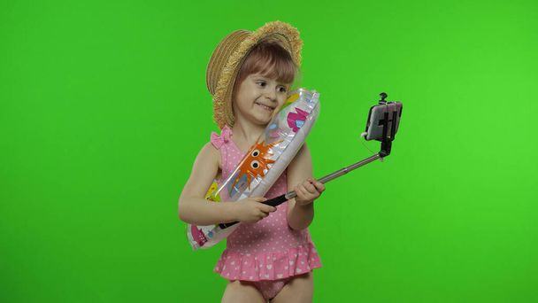 Tyttö lapsi tekee selfie vlog, bloggaaminen, videopuhelu matkapuhelimeen. Lomameri
 - Valokuva, kuva