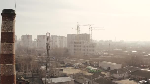 Zbliża się zdjęcie lotnicze krajobrazu miasta i budowy nowych budynków biurowych i mieszkaniowych oraz dźwigów budowlanych w Charkowie, Ukraina. Obszar przemysłowy miasta z góry. - Materiał filmowy, wideo