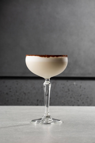 Glasses of Irish cream liqueur with anise, cocoa and ice on gray background. Selective focus. Overhead view, copy space. Advertising for cafe. Bar menu. Vertical photo. - Photo, image