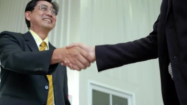 Idősebb ázsiai üzletember kezet rázott, beleegyezett az együttműködésbe. - Felvétel, videó