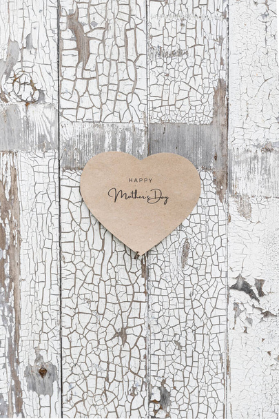 Ευτυχισμένη Ημέρα της Μητέρας γραμμένο σε μια κάρτα χαρτί σε ένα ρουστίκ παλιό τοίχο, πόρτες - Φωτογραφία, εικόνα
