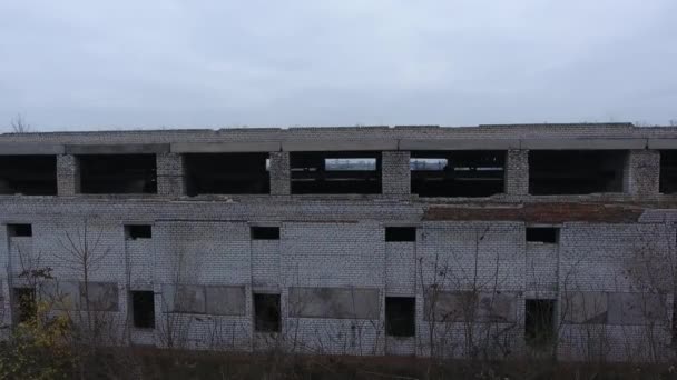 Luftaufnahme. Ruiniertes altes Backsteingebäude, Boxen für Autos und militärische Ausrüstung - Filmmaterial, Video