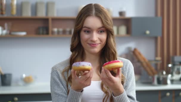 Woman playing with cakes indoors. Funny girl having fun with colorful donuts. - Video