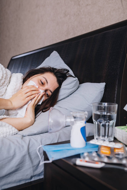 Μια άρρωστη γυναίκα στο κρεβάτι πίνει χάπια. αντίγραφο χώρου - Φωτογραφία, εικόνα