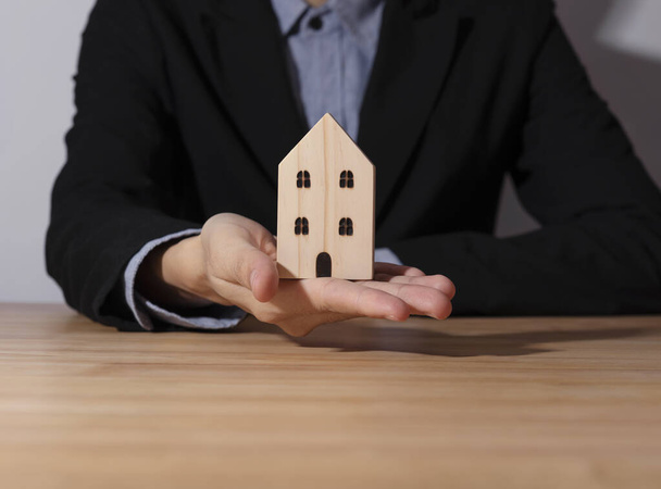 Vente d'affaires main agent offre maison en bois. concept assurance habitation et résidence
. - Photo, image