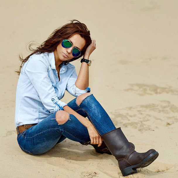 Открытый модный портрет стильной женщины в джинсах и солнечных очках
 - Фото, изображение