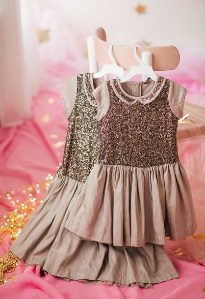 服の上の子供のドレスはハンガー。女の子の最初の誕生日のためのドレス - 写真・画像