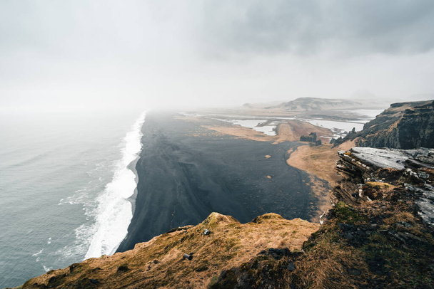 Moody Black Sand Beach na Islândia durante o tempo chuvoso e nebuloso reflete as condições climáticas típicas dos países do norte - Foto, Imagem