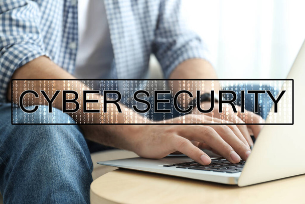 Cyber security concept. Man working with laptop at table indoors, closeup - Foto, Imagem