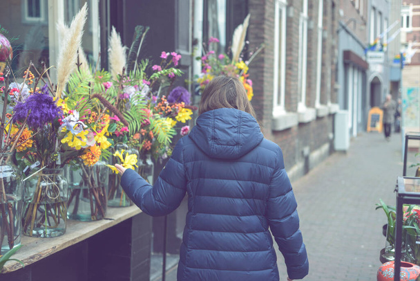 Young smiling woman selecting fresh flowers - Photo, Image