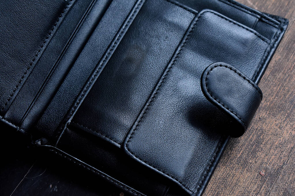 carteira de couro preto em um fundo de madeira leve
 - Foto, Imagem